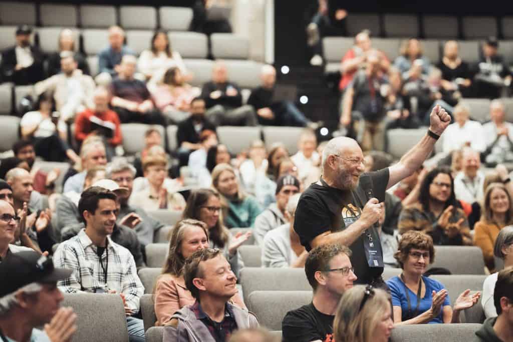 Man cheering amidst crowd at Reach Australia National Conference 2023